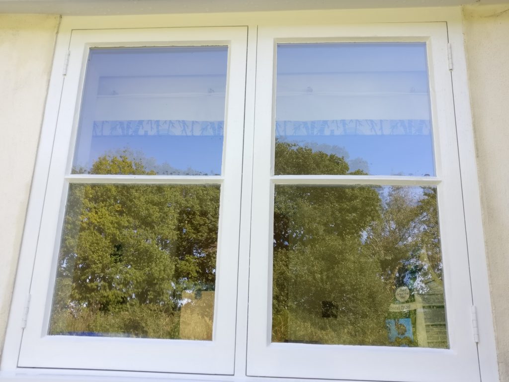 call us today! 07380390757. window cleaning the way it should be done - reflections on a farm cottage window. Experienced and expert window cleaning.