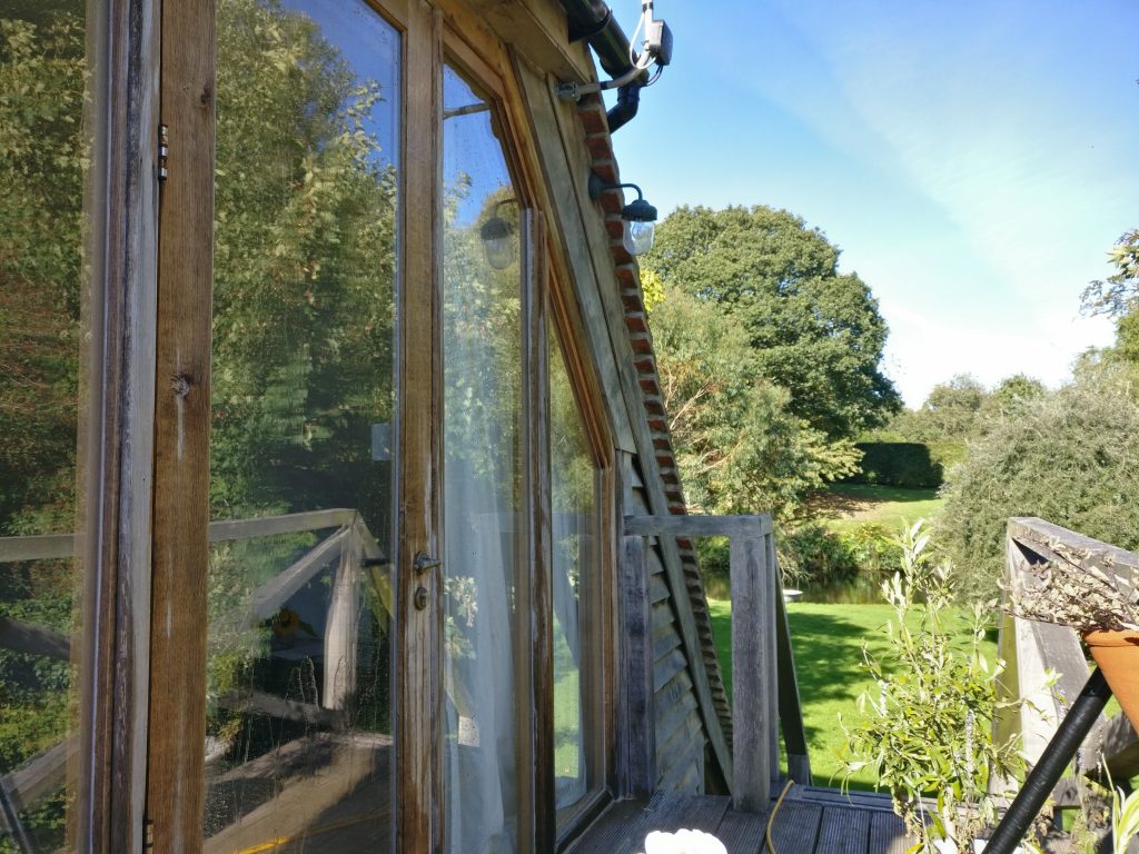 Clean oak-framed windows reflecting the countryside