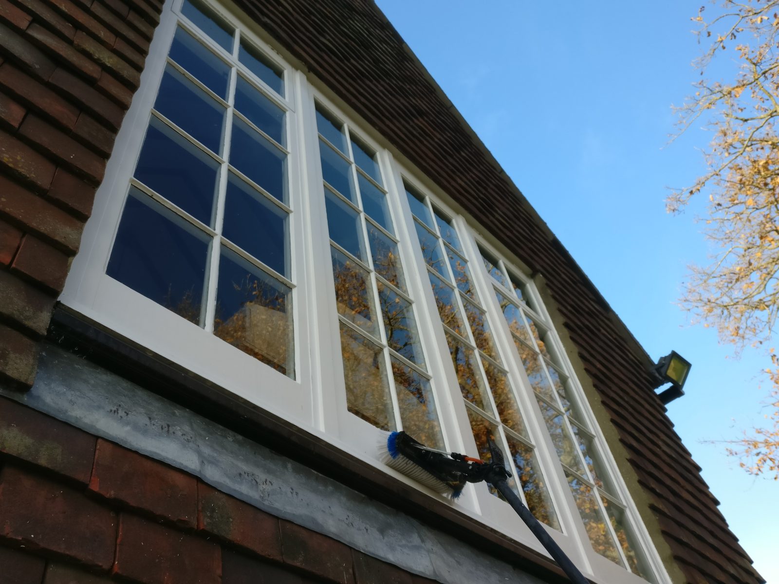 First floor wooden frame Georgian windows being cleaned close to Fletching in East Sussex