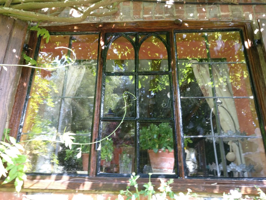 Clean leaded windows reflecting a summer garden