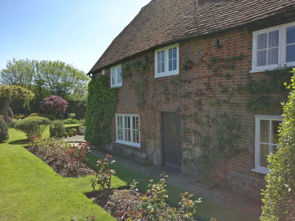 Georgian windows at a country cottage with a garden in the foreground