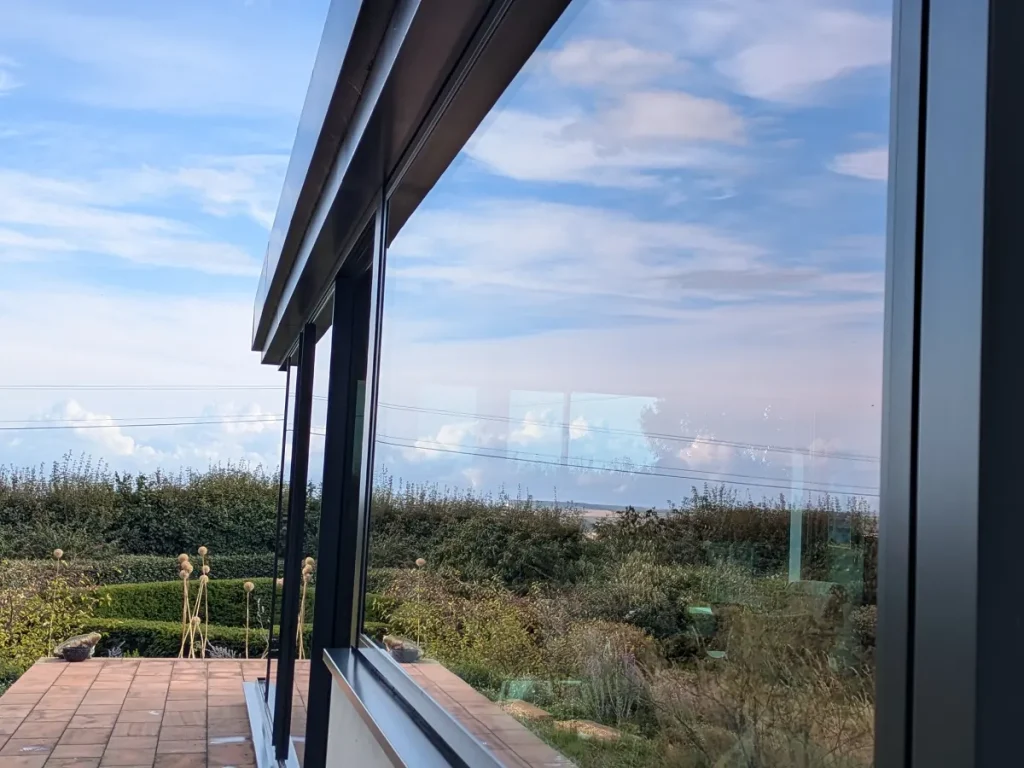 Clean modern windows reflecting the sky and garden